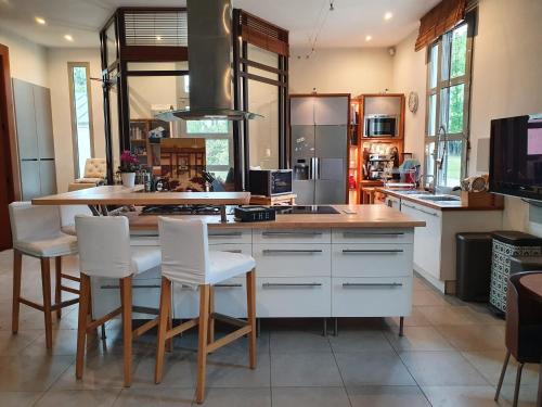 Il dispose d'une cuisine avec un îlot pourvu de chaises blanches. dans l'établissement villa Droizy, à Droizy