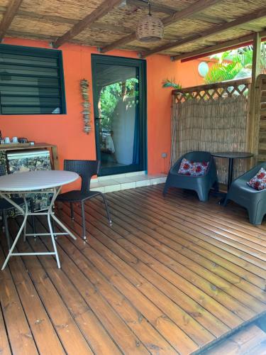 a wooden deck with a table and chairs on a house at Les Manguiers in Deshaies