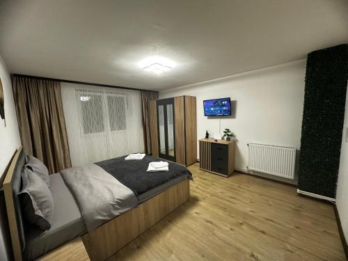 a bedroom with a bed and a tv on the wall at Central Studio in Piteşti