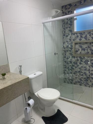 ein Badezimmer mit Toilette und Glasdusche in der Unterkunft Céu e mar Rua marechal Hermes da Fonseca 37 Praia Grande centro Espaço todo reservado para hóspede in Arraial do Cabo
