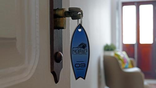 a door opener with a surfboard hanging on a door at Furadouro Surf Camp (Studios) in Ovar