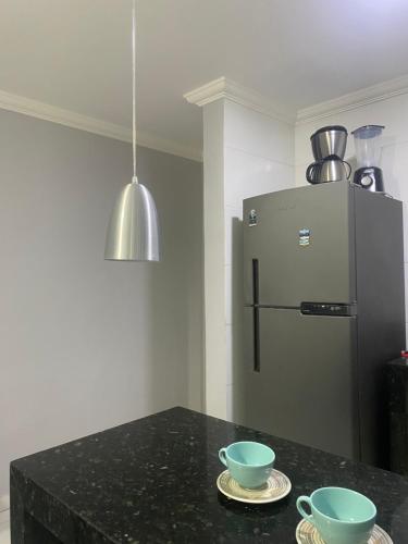 eine Küche mit zwei Schüsseln auf einer Theke mit einem Kühlschrank in der Unterkunft Céu e mar Rua marechal Hermes da Fonseca 37 Praia Grande centro Espaço todo reservado para hóspede in Arraial do Cabo