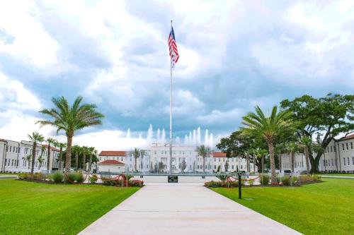 a white building with an american flag on top of it at Centennial Plaza Resort Gulfport in Gulfport