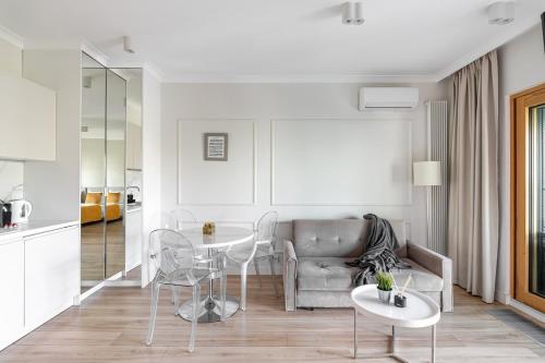 ein Wohnzimmer mit einer Couch und einem Tisch und Stühlen in der Unterkunft Luxury 2-room apartment with a beautiful city view in Warschau