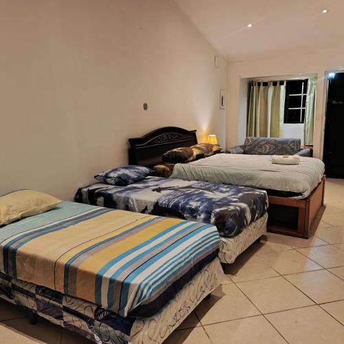 a bedroom with three beds in a room at Vista Boquete Apartments in Bajo Boquete