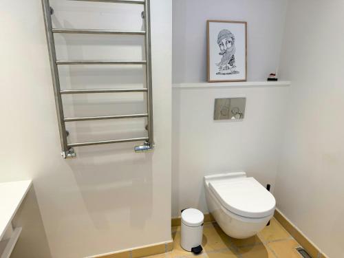 a small bathroom with a toilet and a shelf at Town House With Sea View In Historic Ærøskøbing in Ærøskøbing