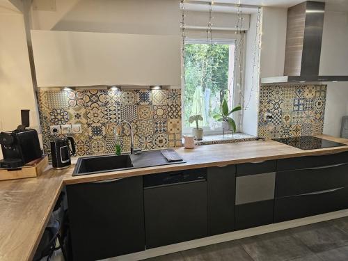 a kitchen with a counter with a sink and a window at Le Refuge Aristide - Cozy - 4ch - Grand parking gratuit in Cravanche