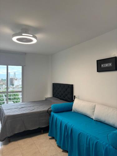 Un dormitorio con una cama con una manta azul. en Loft - Zona hospitales - Familias!, en Rosario