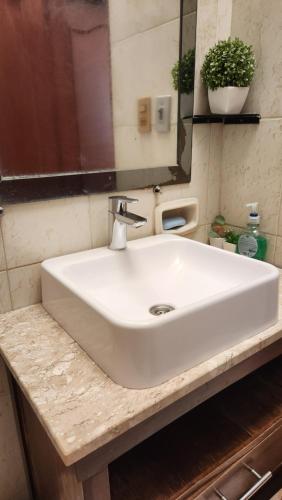 a white sink in a bathroom with a mirror at Sala en Casa Familiar para 2 personas in Asuncion