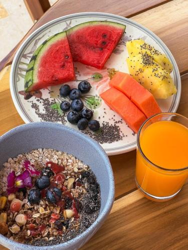 una mesa con un plato de comida y un vaso de jugo de naranja en Fina Estampa Country Hotel - Mayores de 10 años, en Támesis