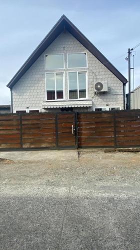 a house with a wooden fence in front of it at Hospedaje Angaroa a 15 min del centro in Puerto Montt
