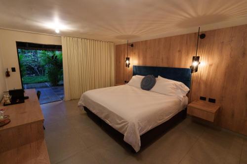 a bedroom with a large white bed with a wooden wall at GUAJIRA CASA DEL MAR in Ríohacha