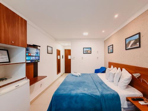 a hotel room with a bed and a tv at Ponta Negra Beach Praiano Flat in Natal