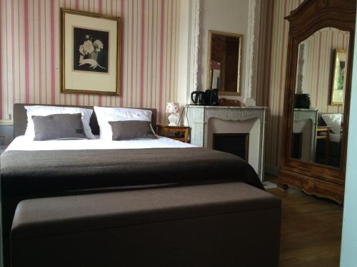 a bedroom with a large bed and a fireplace at Domaine La Reveille in Dore-lʼÉglise