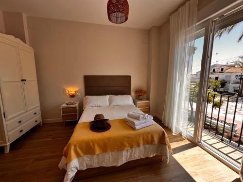 ein Schlafzimmer mit einem Bett, auf dem ein Hut liegt in der Unterkunft Casa Villamezquita in Villarrasa