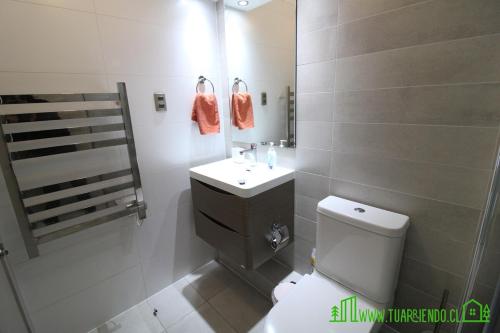 a bathroom with a toilet and a sink and a mirror at MPH 204 Departamento en Puerto Varas a pasos del Lago, para 6 personas in Puerto Varas