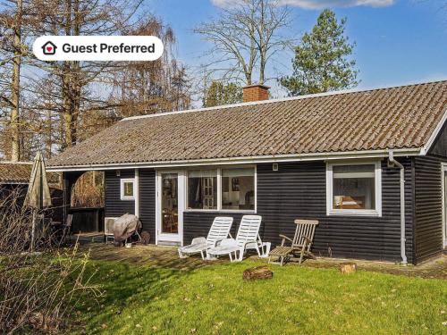 a black house with two chairs and a house at 5 person holiday home in Ansager-By Traum in Ansager