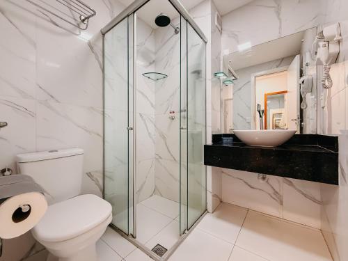 a bathroom with a shower and a toilet and a sink at Ponta Negra Beach Praiano Flat in Natal