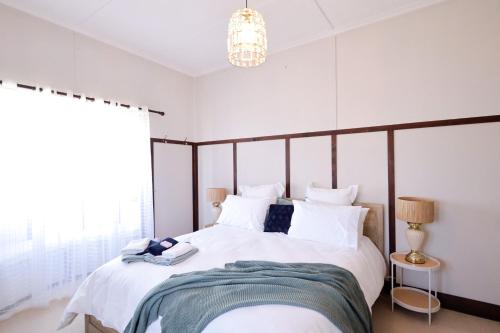 ein Schlafzimmer mit einem großen Bett mit weißer Bettwäsche in der Unterkunft Heritage Home with BBQ & Outdoor Fire Pit in Tenterfield