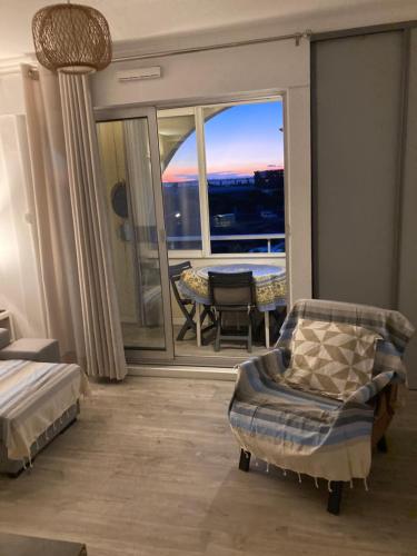 a bedroom with a balcony with a bed and a table at Studio belle vue in Sète
