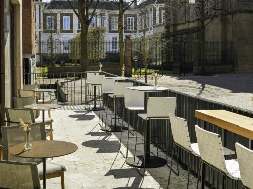 una fila de mesas y sillas en un patio en Mövenpick Hotel The Hague, en La Haya