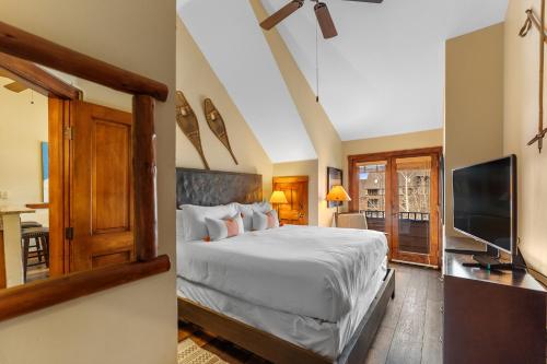 ein Schlafzimmer mit einem großen Bett und einem Fernseher in der Unterkunft Arapahoe Lodge 8137 in Snake River Health Services Incorporated Heliport