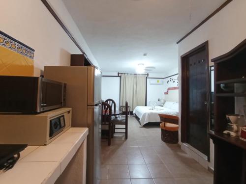 a hotel room with a bed and a television in a room at Suites Fenicia in Playa del Carmen