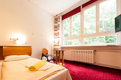 ein Schlafzimmer mit einem Bett und einem großen Fenster in der Unterkunft Seminarhaus Europäische Akademie in Waren (Müritz)