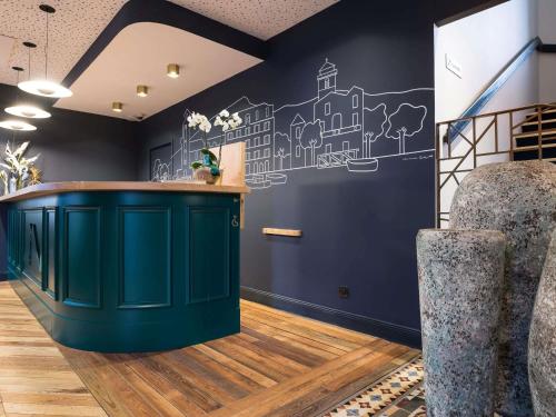 a bar in a room with a blue wall at MADISON Saint Jean de Luz - Handwritten Collection in Saint-Jean-de-Luz