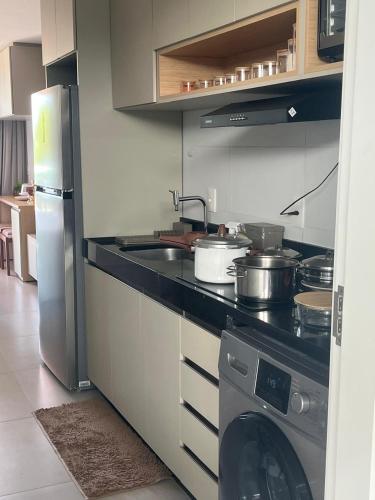 a kitchen with a stove and a sink and a dishwasher at Flat in Tamandaré
