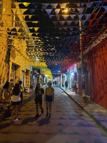 een groep mensen die 's nachts over straat lopen bij hotel Siboney - Centro in Estación El Salto