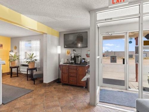 a living room with a sliding glass door with a view of a room at 1st Choice Inn of Rawlins in Rawlins