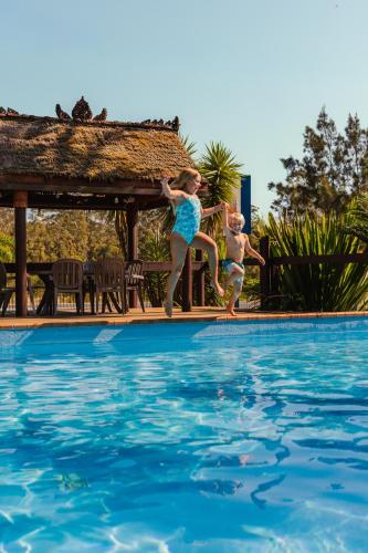 two children jumping into a swimming pool at The Pelican Caravan Park Nambucca Heads in Nambucca Heads