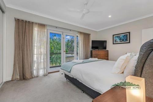 Un dormitorio con una cama y una ventana grande en Campaspe Central - Your Central Echuca Escape!, en Echuca