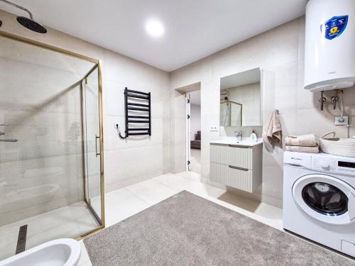um banheiro com chuveiro e máquina de lavar em BunApart Ciorescu Cristal em Ciorescu
