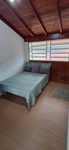 ein Schlafzimmer mit einem Bett in einem Zimmer mit Holzdecken in der Unterkunft Le Flat Petrópolis in Petrópolis