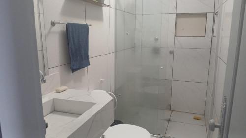a white bathroom with a shower and a toilet at Alugo casa para COP 30 in Belém