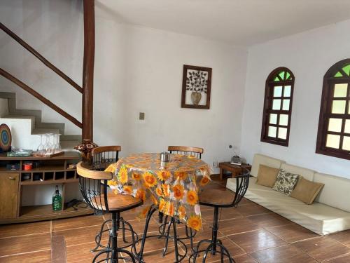 a living room with a table with chairs and a couch at Chale com Hidromassagem na Serra do Cipó in Santana do Riacho