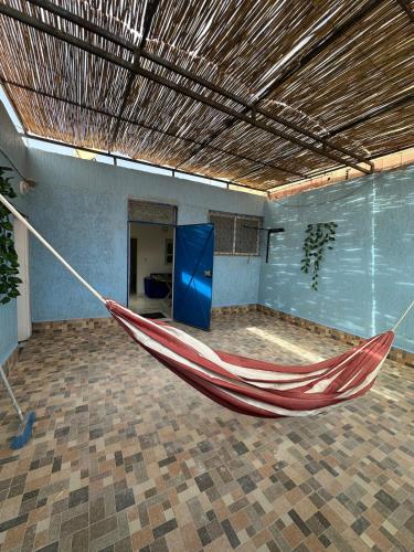 una hamaca roja en una habitación con una puerta azul en A unique and cute apartment in a prime location, en Er Rachidia