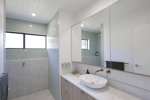 Un baño con lavabo y un espejo grande. en Off-Grid Farm Stay with Scenic Views, en Tenterfield