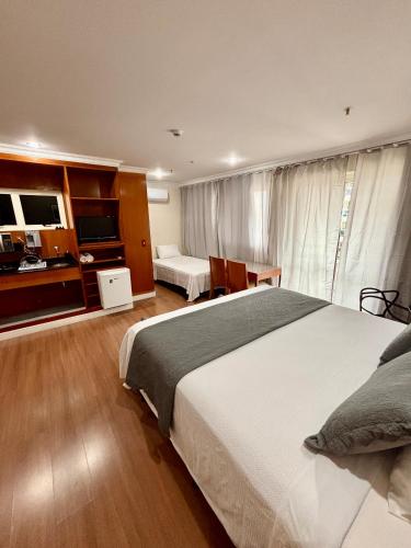 a hotel room with two beds and a television at Flat Barra Residence-3 pessoas-Fa1204-4 in Rio de Janeiro