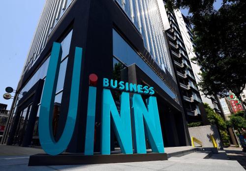 a building with a sign for a business firm at Uinn Business Hotel-Shihlin in Taipei