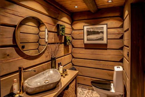 a bathroom in a log cabin with a sink and a mirror at Cabin With Great Fishing At Trysilfjellet in Jordet