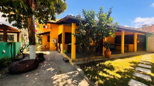 a yellow house with a tree in front of it at Pousada 100 passos in Tamandaré
