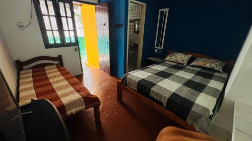 a bedroom with two beds in a room with a window at Pousada 100 passos in Tamandaré