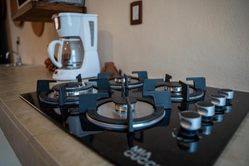 a kitchen counter with a stove top with cups on it at Cielito Lindo Hotel Boutique 