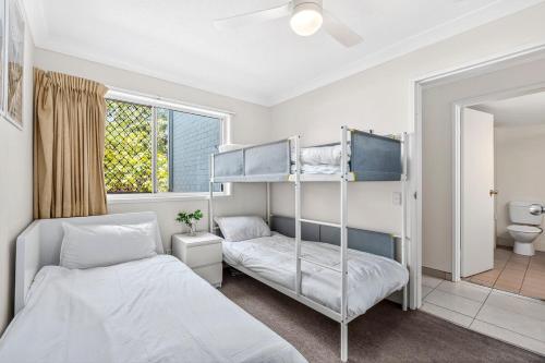 a bedroom with two bunk beds and a bathroom at Villa Sienna Hideaway 2 min walk to tramline in Gold Coast