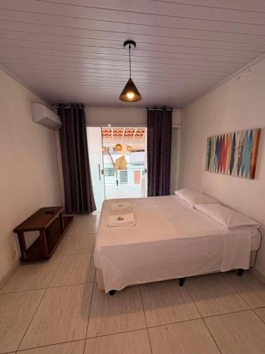a bedroom with a large bed and a window at Casa em condominio bem no centro in São Sebastião