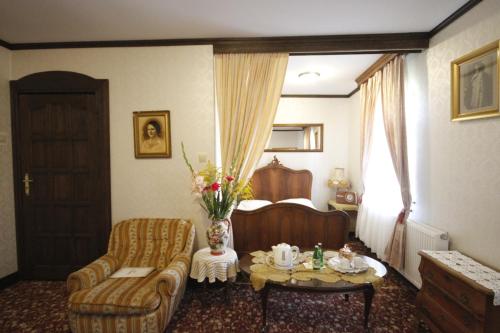a living room with a couch and a chair at Kiermusy Dworek nad Łąkami in Kiermusy