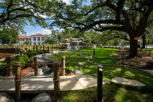 a park with a fountain and a tree at Centennial Plaza Resort Gulfport in Gulfport